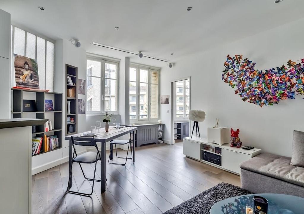 un salon avec une table et des chaises dans l'établissement Bright & Modern Flat in le Marais - An Ecoloflat, à Paris