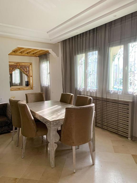 a dining room with a wooden table and chairs at Le luxe de Sidi Bou Saïd in Sidi Bou Saïd