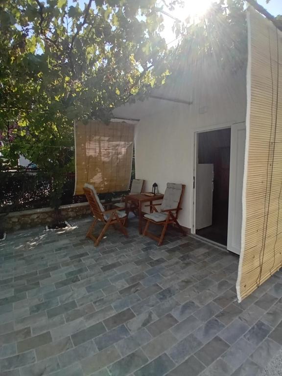 a patio with chairs and a table and a tent at Apartmani Vrzić in Baška