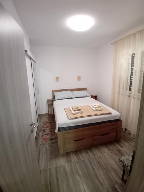 a bedroom with a bed in a white room at Apartmani Vrzić in Baška