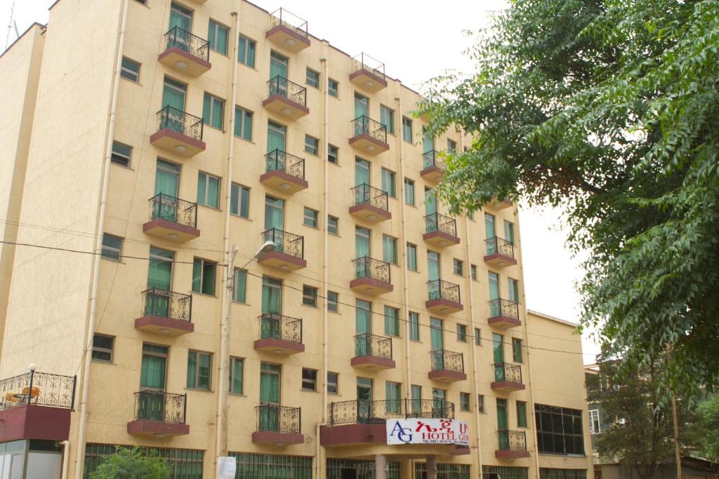 duży budynek z balkonami i znakiem na nim w obiekcie AG Hotel Gondar w mieście Gonder