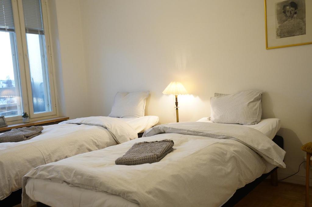 two twin beds in a room with a window at Cozy apartment with view in Kajaani