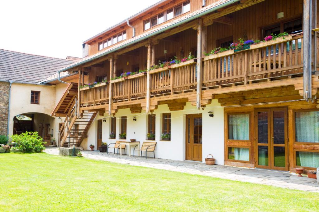 a large house with wooden balconies and a yard at Selsky Dvur in Kájov