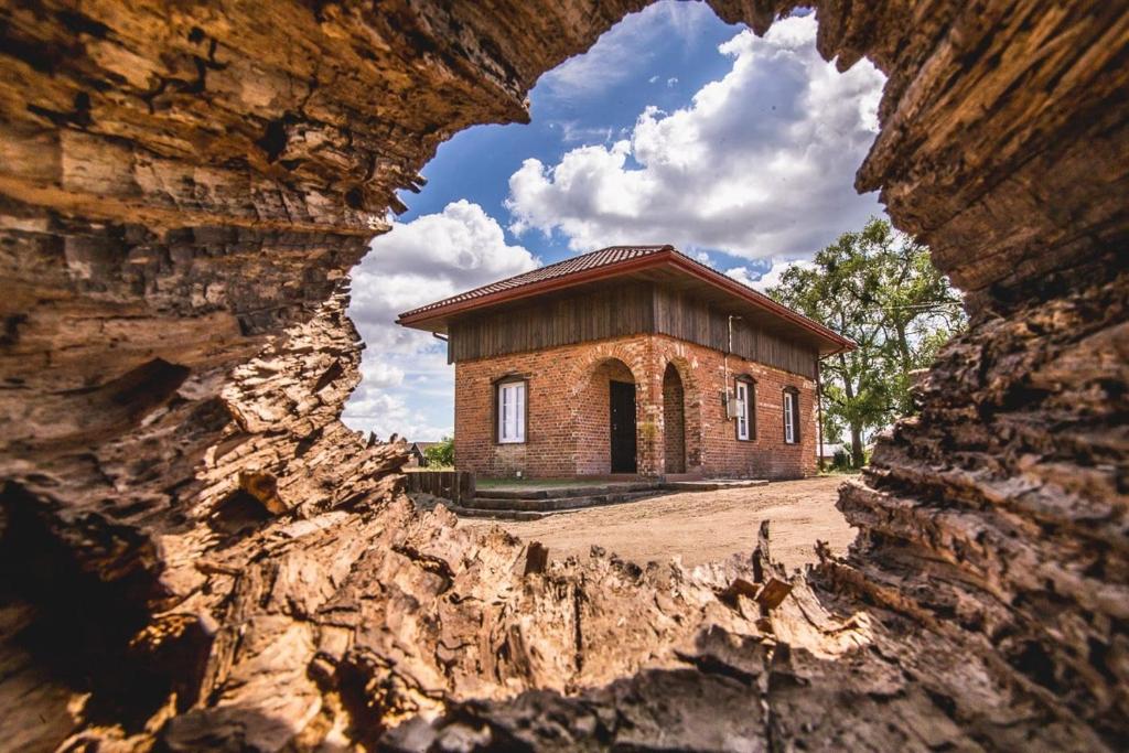 a small brick building through a rock formation at Stara Pompka Studio na Górze in Czeremcha
