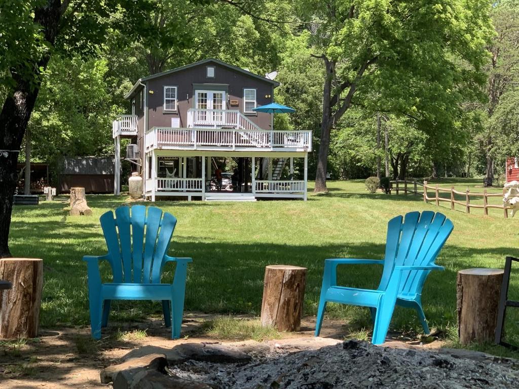three blue chairs sitting in front of a house at Bear Valley- Riverfront with hot tub - Starlink Satellite Wi-Fi in Goods Mill