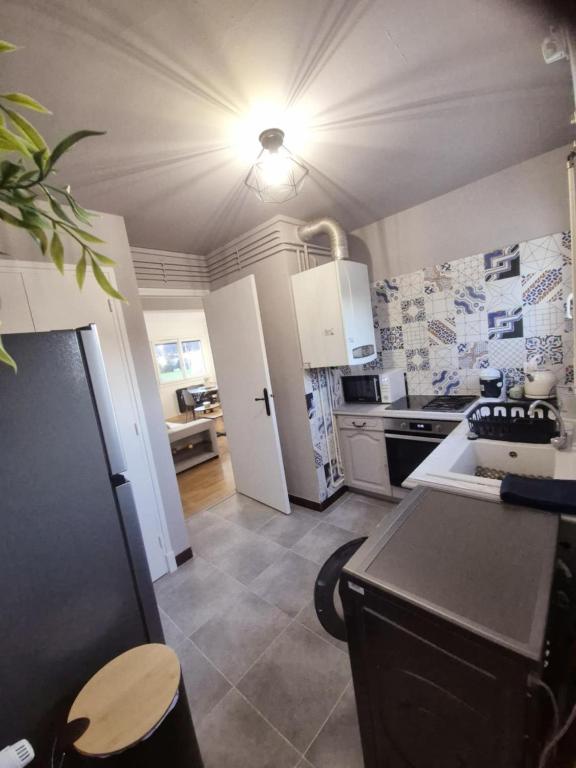 une cuisine avec un r&eacute;frig&eacute;rateur et un plan de travail dans l'&eacute;tablissement Une belle Escapade &agrave; Lourdes, &agrave; Lourdes