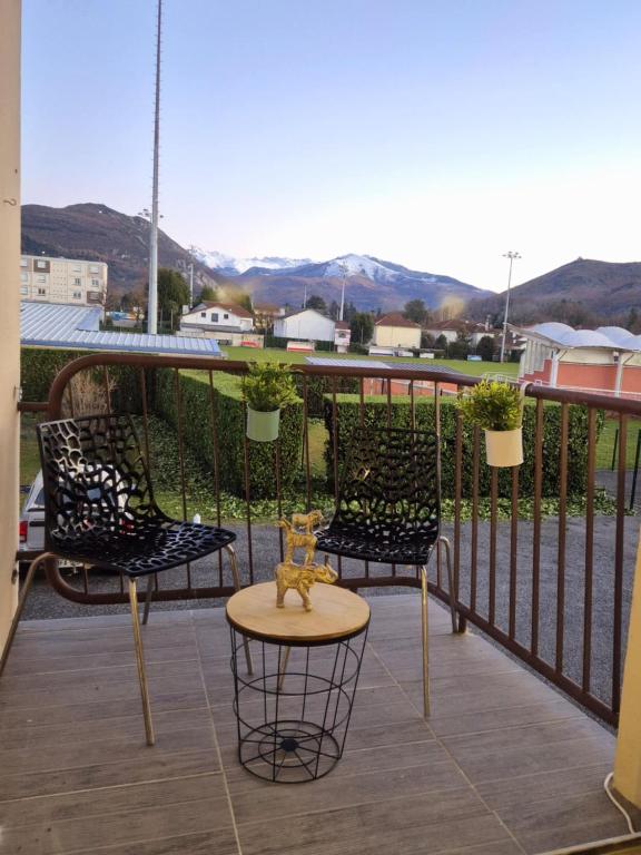 un patio avec trois chaises et une table sur un balcon dans l'&eacute;tablissement Une belle Escapade &agrave; Lourdes, &agrave; Lourdes