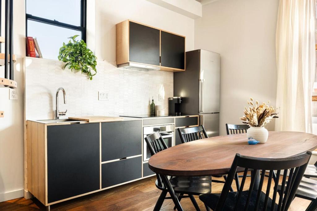 a kitchen with a wooden table and a dining room at Luxury Loft near Washington Park - Rooftop Deck in Cincinnati