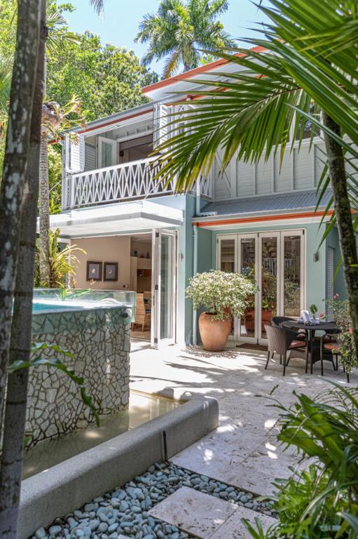 a house with a patio and a table in front of it at Courtyard on Murphy Tropical Oasis in Town in Port Douglas