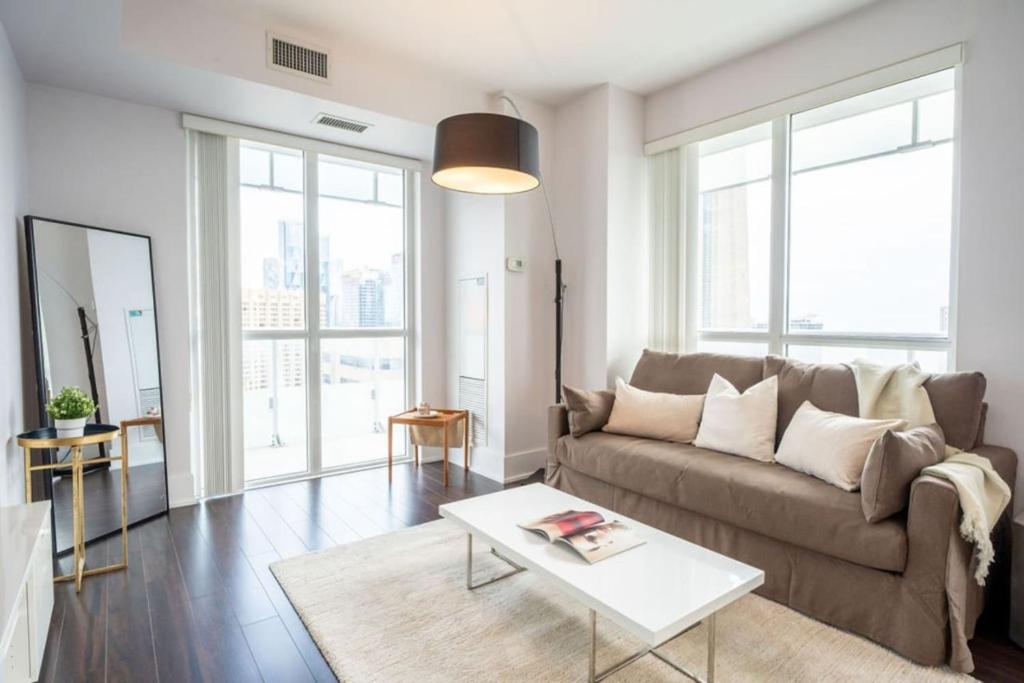 a living room with a couch and a table at Luxury Condo with Pool, CN Tower View, Gym, Workspace in Toronto