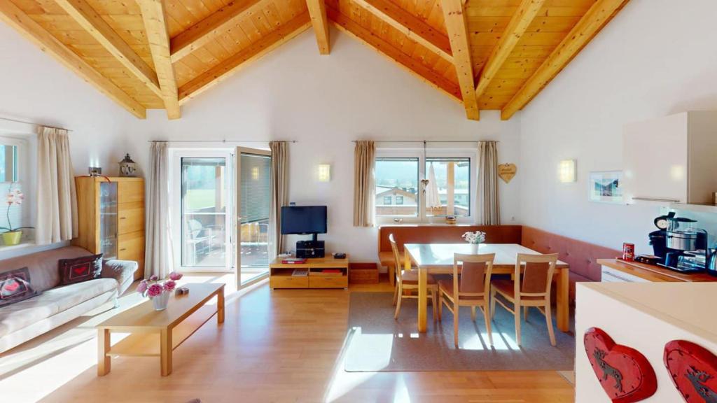 a kitchen and living room with a table and chairs at Haus Christine in Neukirchen am Großvenediger