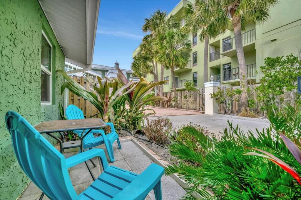 a patio with blue chairs and a table at Stones Throw Beachside Bungalow #2 AT THE BEACH in Clearwater Beach
