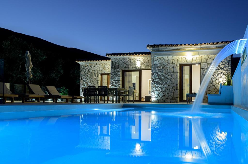 a villa with a swimming pool at night at Angel Villa Zante in Lithakia