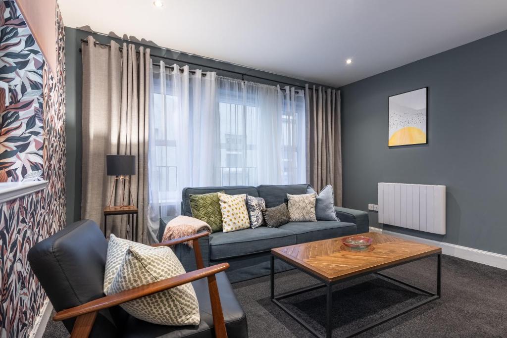 a living room with a blue couch and a table at Ness Central in Inverness