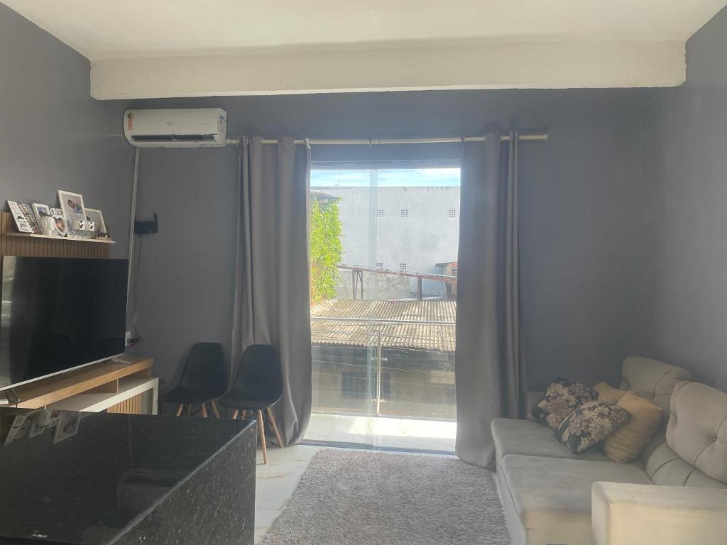 a living room with a couch and a large window at Casa linda pra alugar na COP 30 in Belém