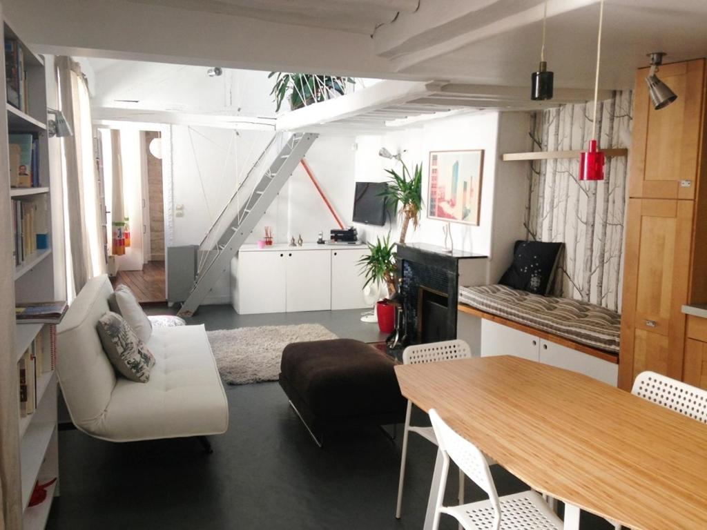 un salon avec un canapé et une table dans l'établissement Charming 2-bedroom duplex Bastille, à Paris