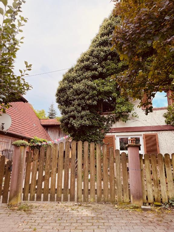 a wooden fence in front of a house at Ferienwohnungen auf einem ehemaligen Bauernhof in Neuhausen