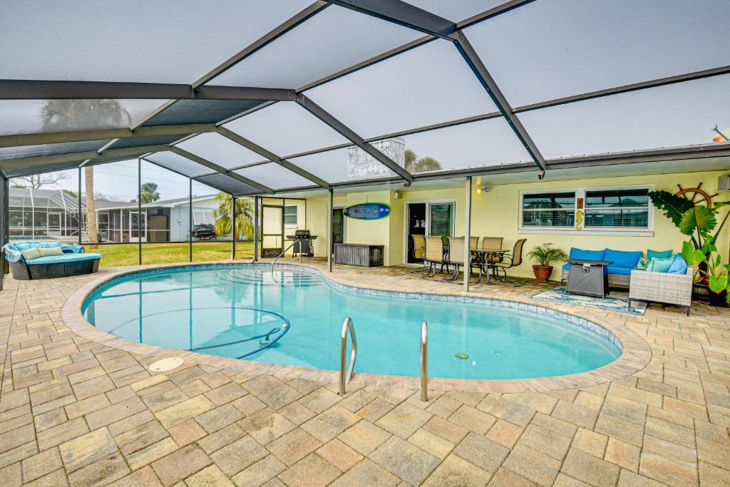una gran piscina con techo retráctil en Sunny South Daytona Home with Pool and Grill!, en South Daytona