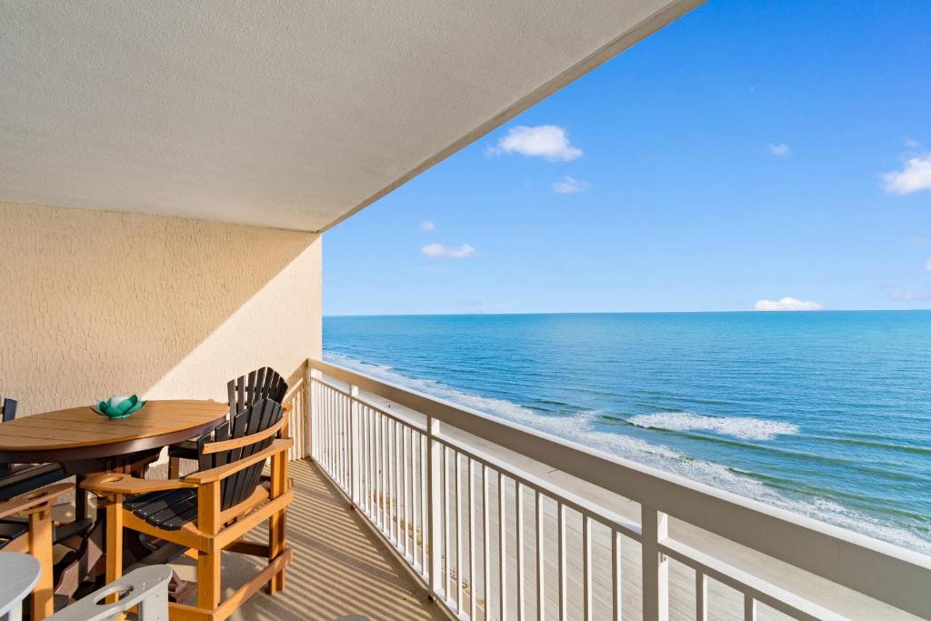 マートルビーチにあるOceanfront Views with 7 Beds, Pools, Lazy River, Gym by myBeach Vacation Rentalsのテーブルと椅子と海のあるバルコニー
