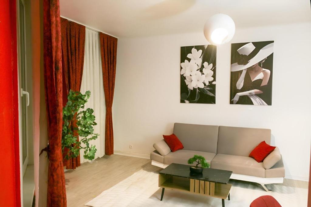 un salon avec un canapé et une table dans l'établissement L'Écarlate - Centre Ville - NyuLocation, à Épinal