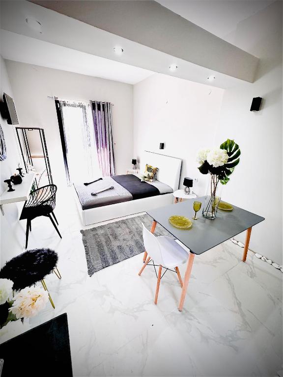 a white living room with a bed and a table at Villa Diamanti in Kolios