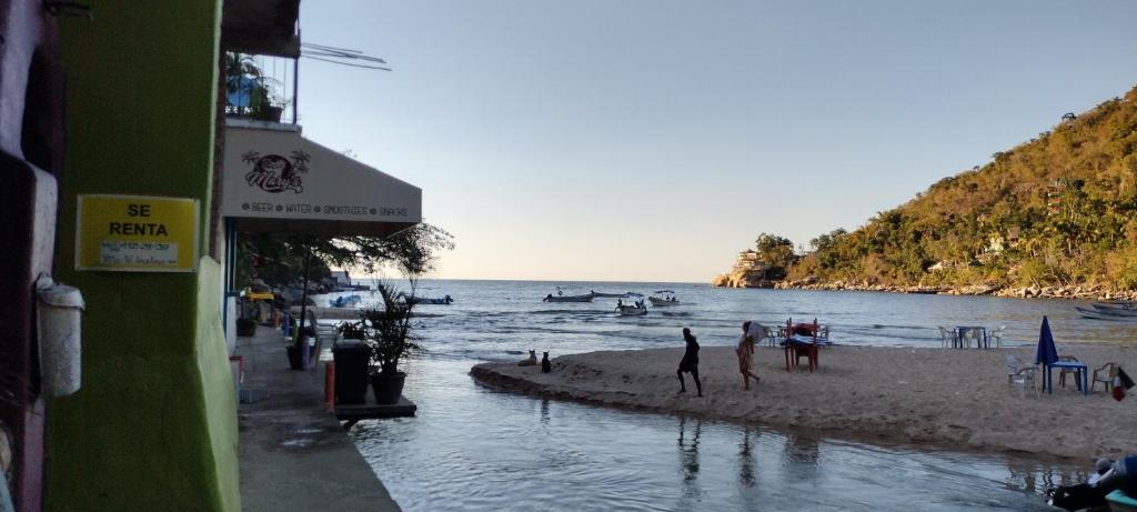 a beach with people on the sand and the water at Villas del Amor Amor in Puerto Vallarta