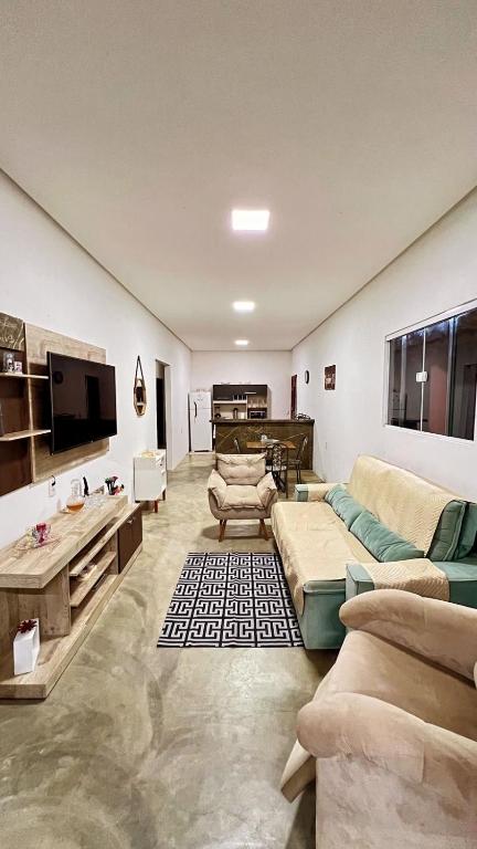 ein großes Wohnzimmer mit Sofas und einem Flachbild-TV in der Unterkunft Residence Tropical Premium in Rio Tinto