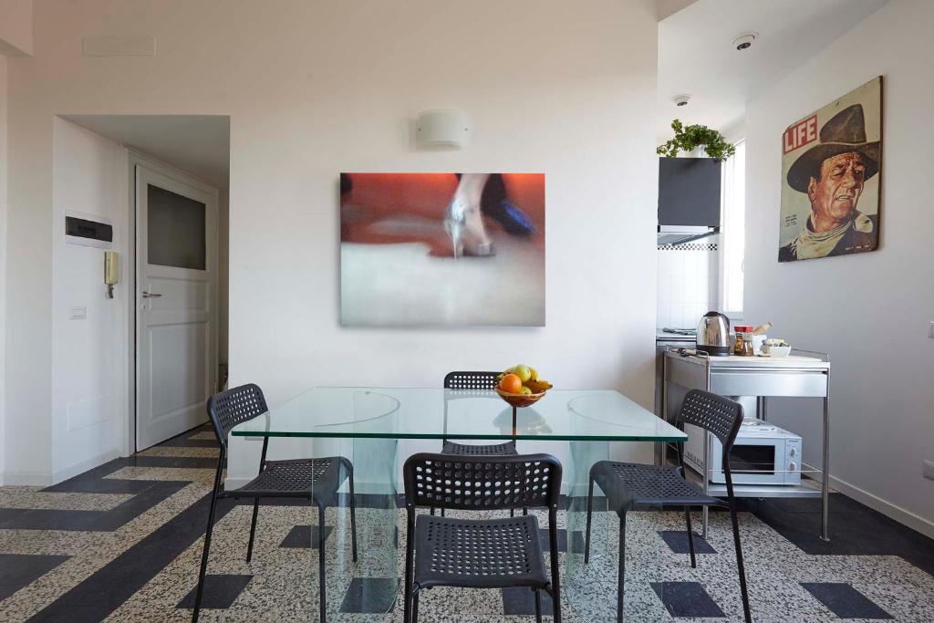 een eetkamer met een glazen tafel en stoelen bij Casa di Franco Navigli in Milaan