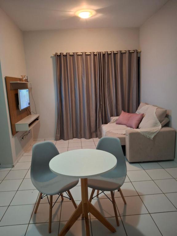 a living room with a table and chairs and a couch at Apartamento aconchegante in Teresina