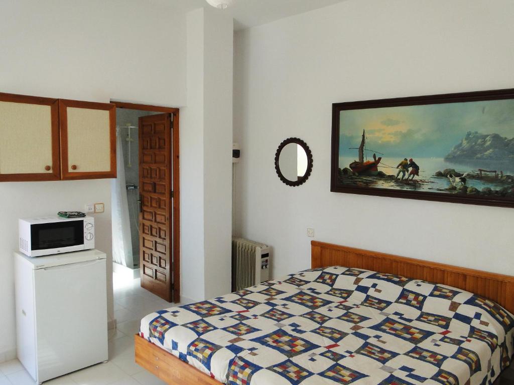 a bedroom with a bed and a painting on the wall at Los Geraneos in Águilas
