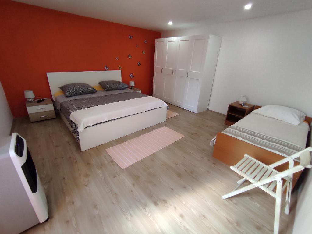 une chambre avec un lit et une chaise dedans dans l'établissement Kuća za odmor Marina, à Sutomišćica