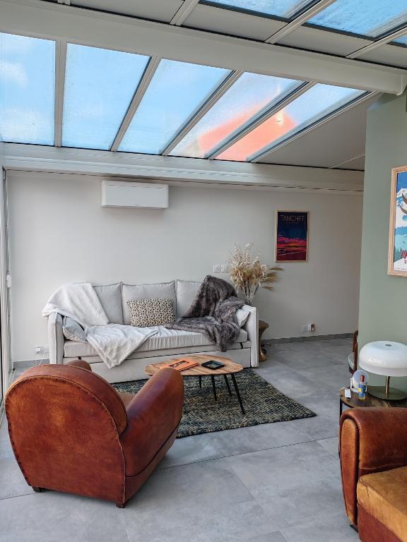 un salon avec un canapé et une table dans l'établissement Maison à 10 min de la plage, à Les Sables-dʼOlonne