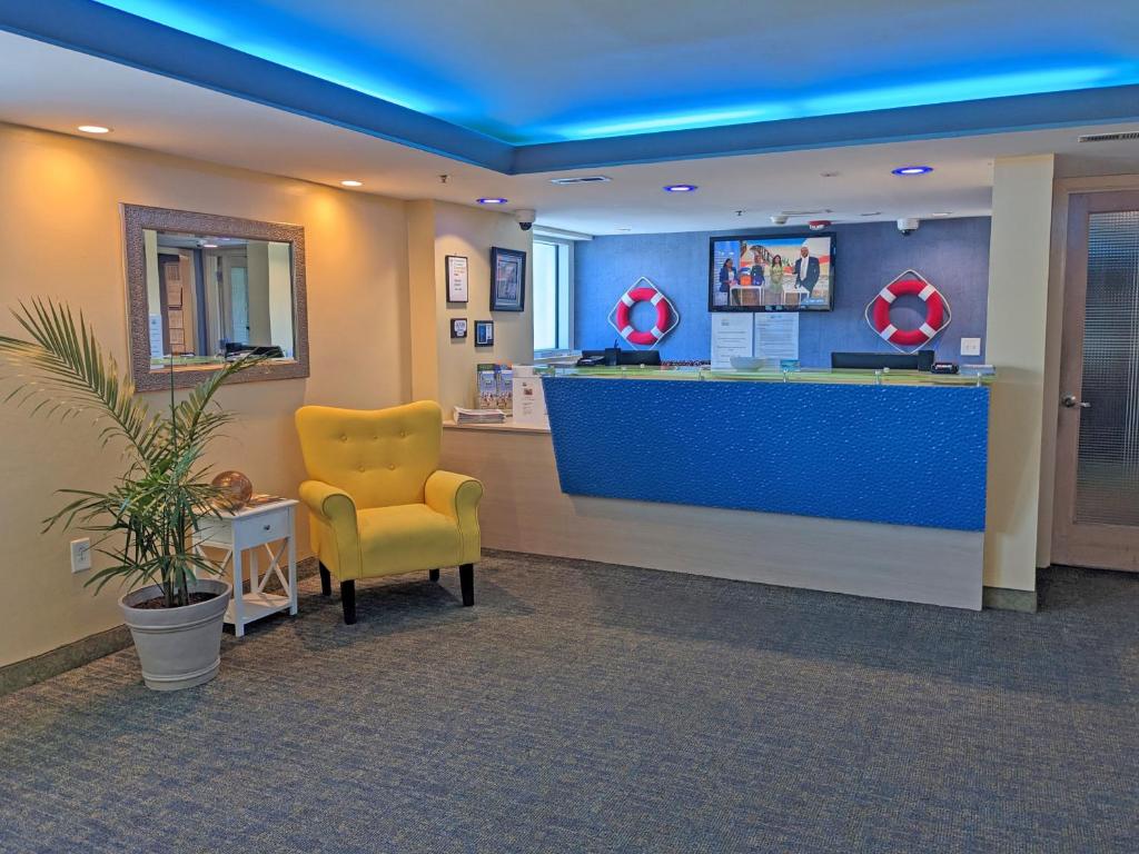 ein Wartezimmer mit einem gelben Stuhl und einer blauen Theke in der Unterkunft Seaside Resort in Myrtle Beach