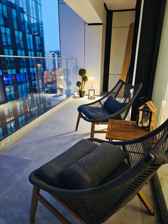 dos sillas en un balcón con vista a una ciudad en MGA Apartment, en Bucarest