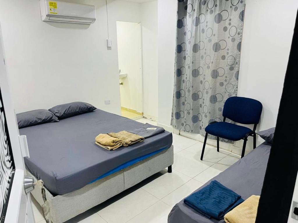 卡塔赫纳Habitación cerca a la playa 105的卧室里有一张床和一把椅子