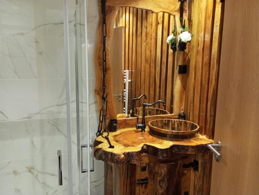 een badkamer met een houten wastafel en een douche bij Casa do Outeiro in Arcos de Valdevez