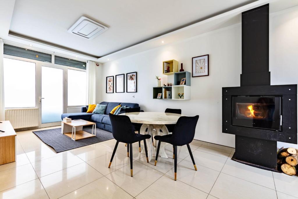 ein Wohnzimmer mit Kamin, Tisch und Stühlen in der Unterkunft Maison spacieuse 3 chambres - 35 min Paris centre in Romainville