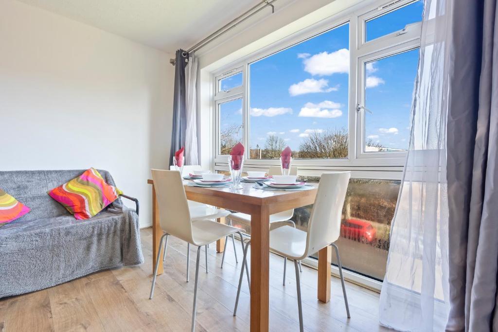 a dining room with a table and chairs and a window at Luxury 2 Bedroom Apartment with Free Parking Opposite Queen Elizabeth Hospital in Birmingham