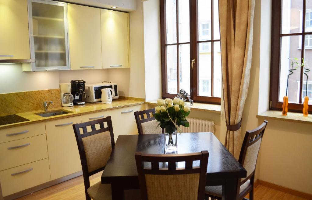 eine Küche mit einem Tisch und einer Blumenvase darauf in der Unterkunft Apartament Dominikański in Danzig
