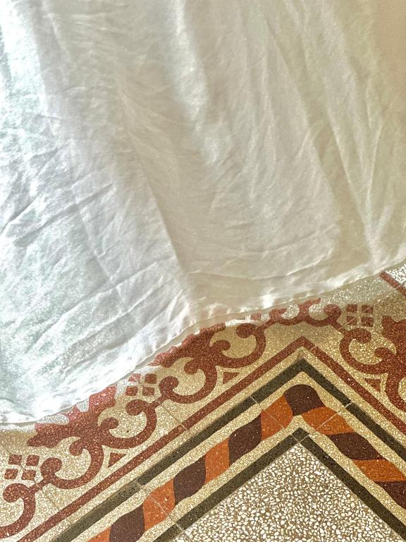a rug on a floor with a white sheet at F Home in Noto