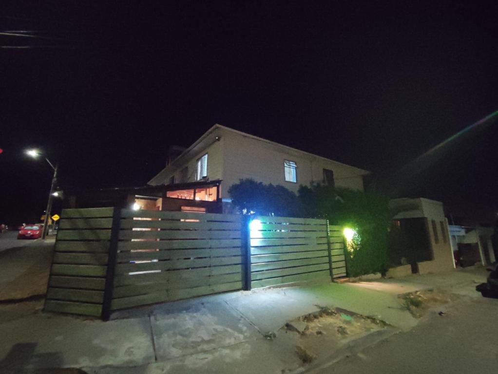 a house with a fence in front of it at night at Casa Isis in Constitución