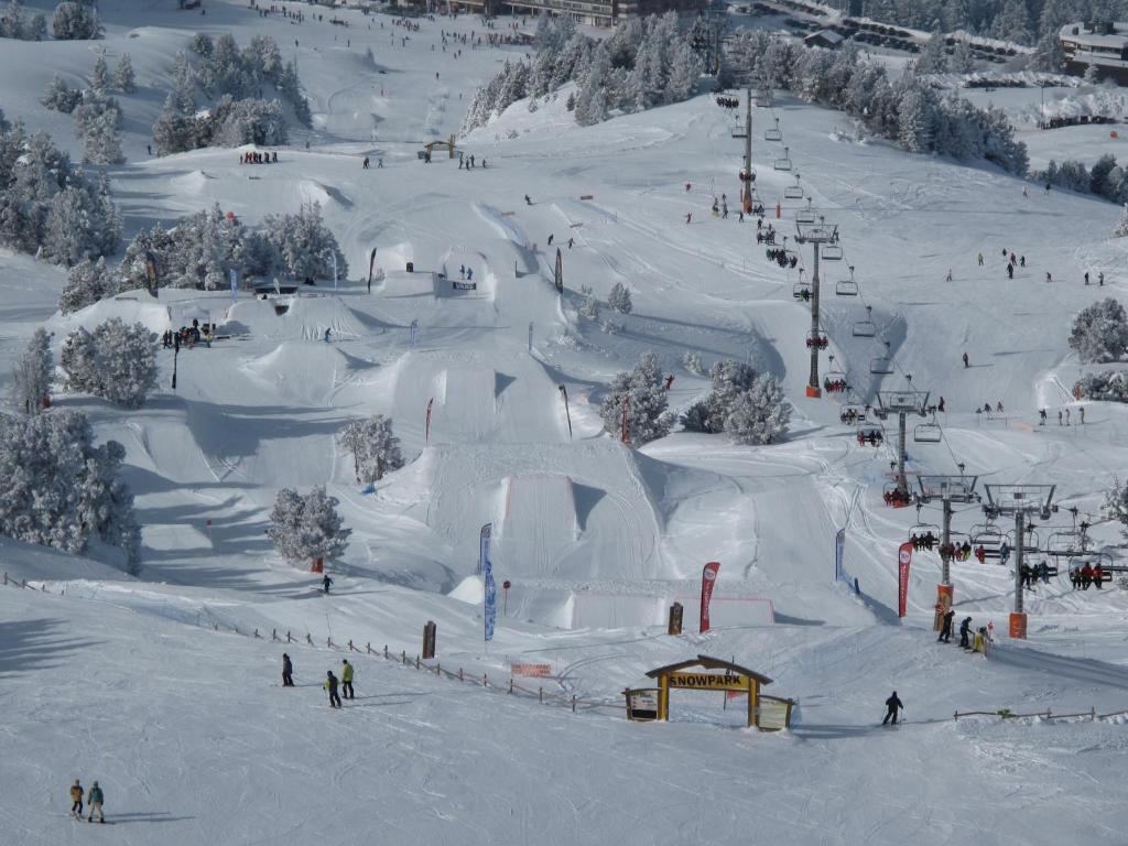 un groupe de personnes skier sur une piste enneigée dans l'établissement Apartment Chamrousse near Ski Lift, à Chamrousse