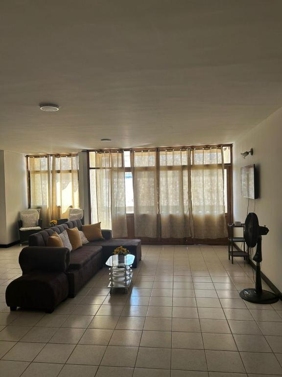 a living room with a couch and some windows at Hostal Tayrona in Santa Marta