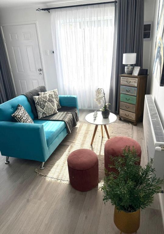 a living room with a blue couch and a table at Departamento Pinela in Punta Arenas