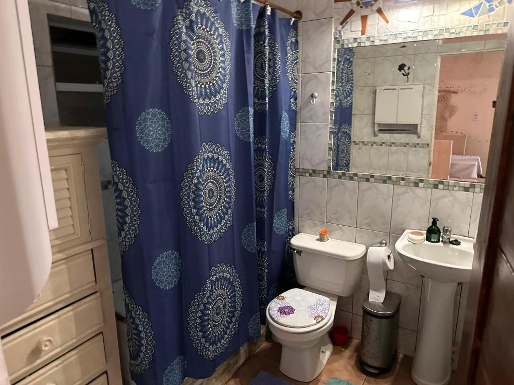 a bathroom with a blue shower curtain and a toilet at Casa Isis in Constitución