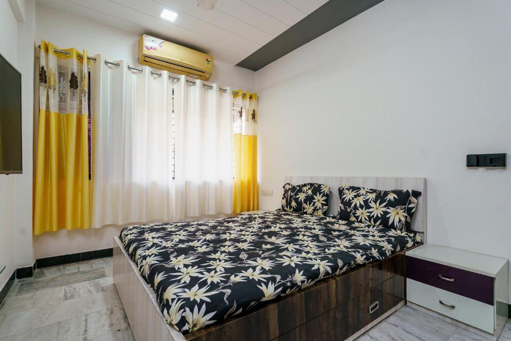 a bedroom with a bed with a black and white comforter at ZenStays - Premium Service Apartment in Mulund West in Mumbai
