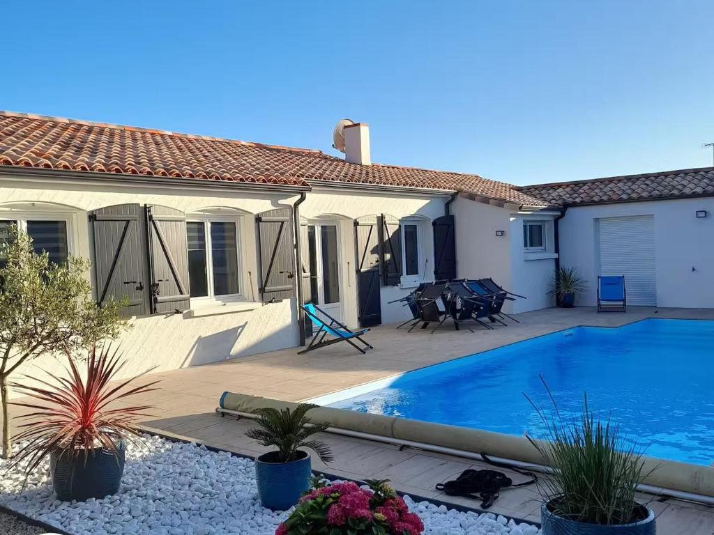 une maison avec une piscine dans une cour dans l'établissement Gîte familial avec piscine chauffée à Bretignolles-sur-Mer - FR-1-426-572, à Bretignolles-sur-Mer