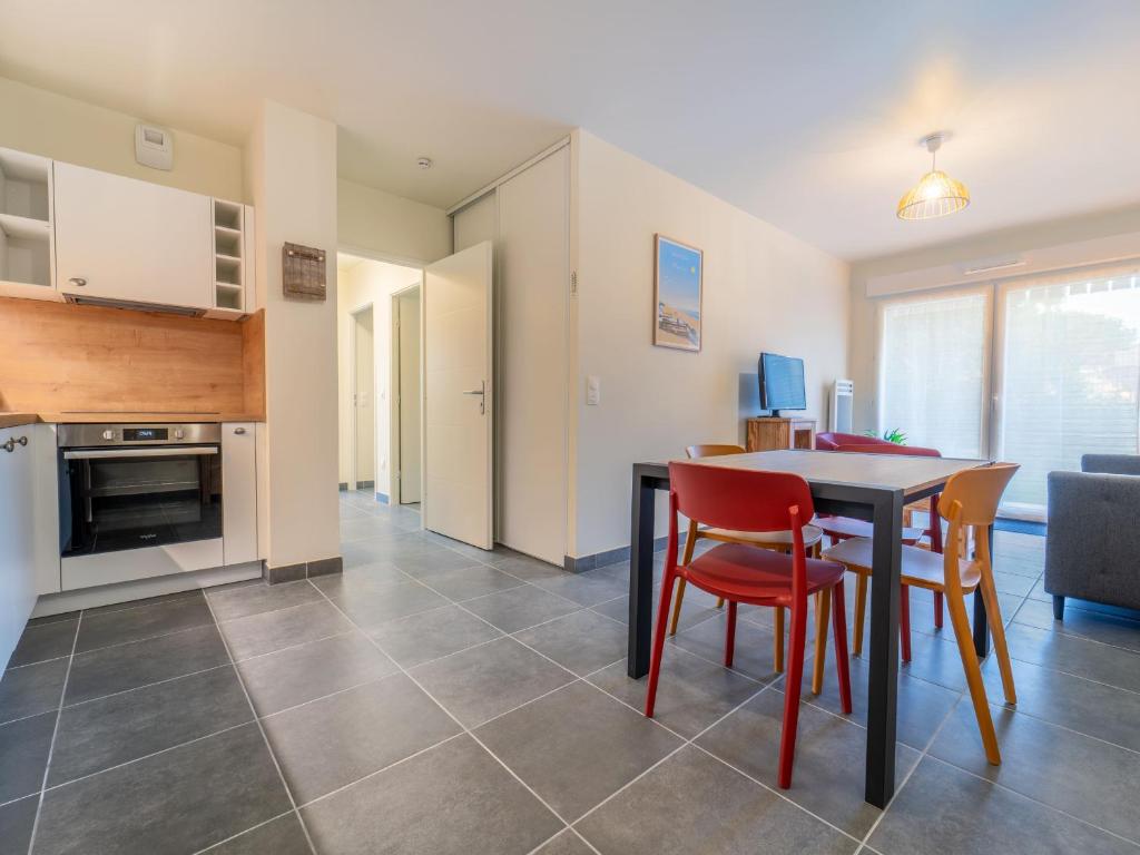 une cuisine et une salle à manger avec une table et des chaises dans l'établissement Appartement Neuf à Mimizan : Confort & Proximité de la Plage avec Parking - FR-1-50-155, à Mimizan