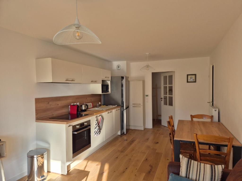 une cuisine et une salle à manger avec une table et une cuisine et une salle à manger dans l'établissement Appartement 4 Personnes - Vue Mer proche Plage - FR-1-482-149, à Fort-Mahon-Plage