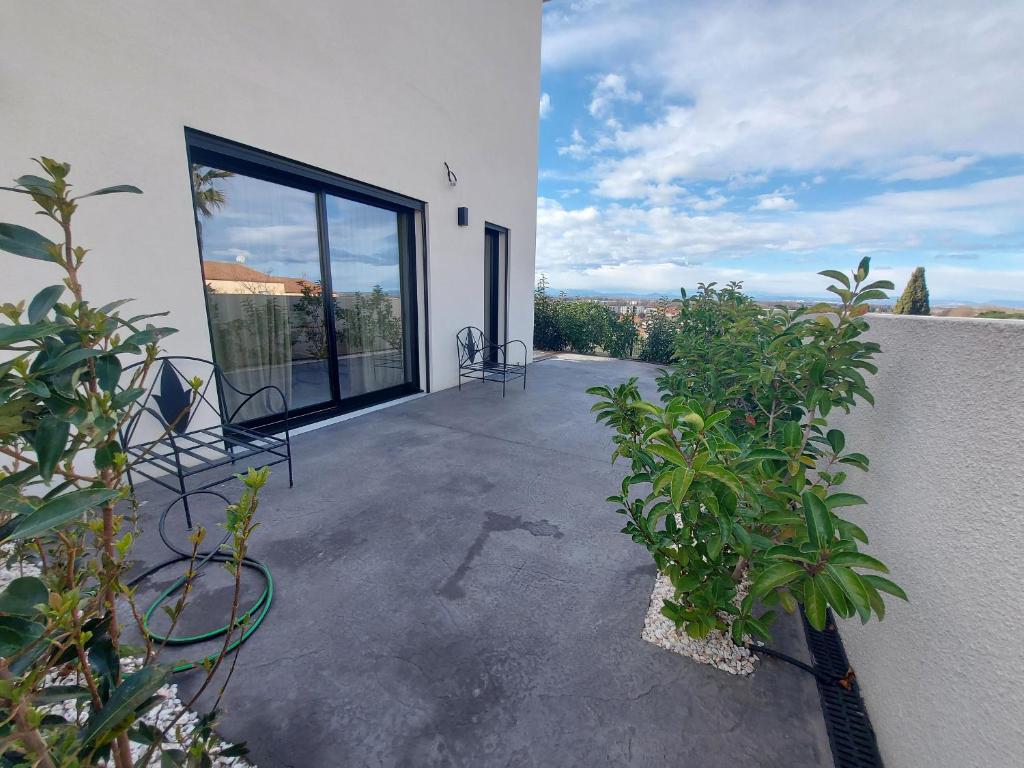 un patio avec des chaises et des plantes sur un bâtiment dans l'établissement Appartement Confortable avec Vue, WIFI et Climatisation - FR-1-776-122, à Saint-Cyprien